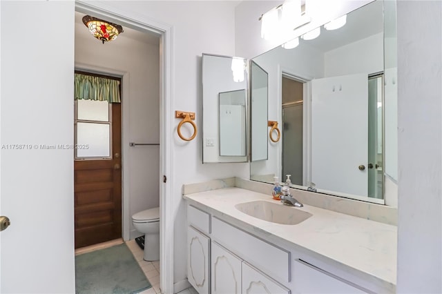 full bathroom featuring tile patterned flooring, toilet, vanity, and a shower with door