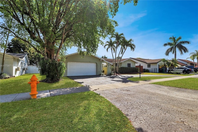 ranch-style home with a front yard, an attached garage, fence, and driveway