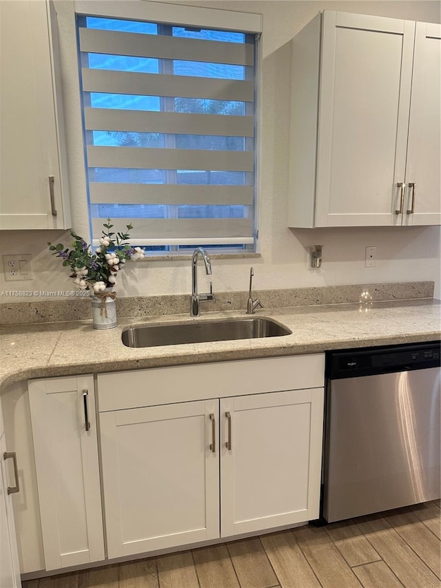 2431 SE 10th Ct, Homestead, FL 33035 - kitchen with wood tiled floor, white cabinetry, a sink, and stainless steel dishwasher