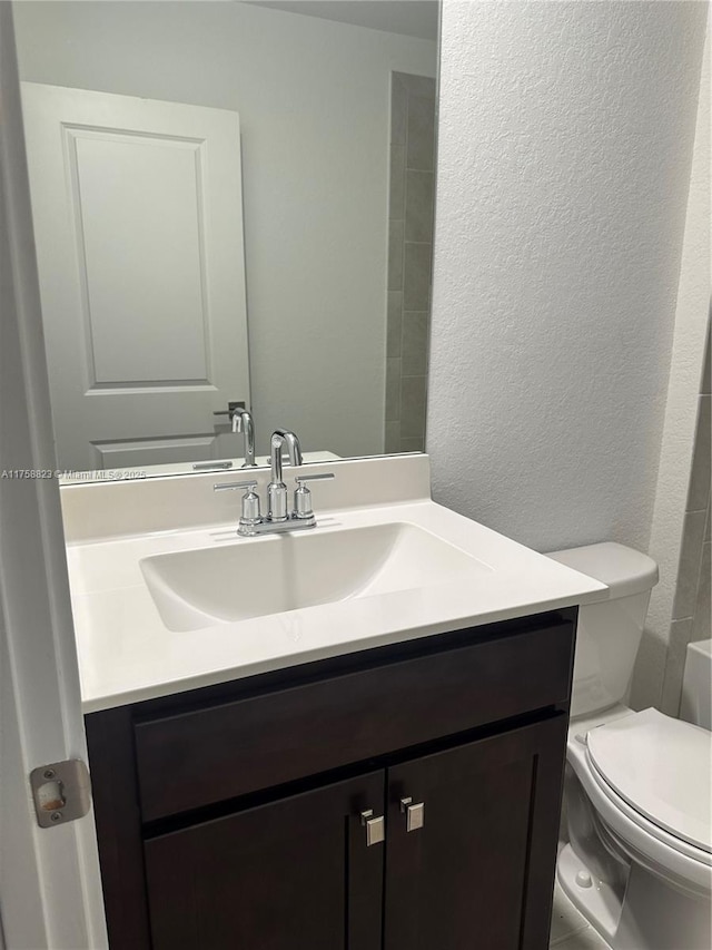 2431 SE 10th Ct, Homestead, FL 33035 - bathroom featuring a textured wall, toilet, and vanity