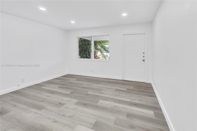 spare room featuring recessed lighting, wood finished floors, and baseboards