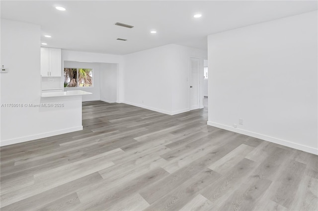 empty room with recessed lighting, baseboards, visible vents, and light wood finished floors