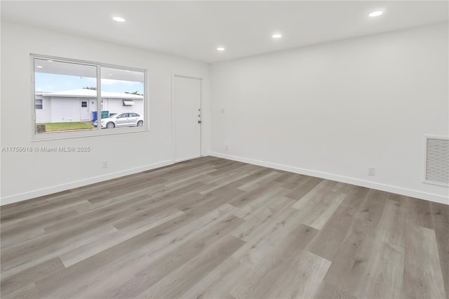 empty room with baseboards, visible vents, wood finished floors, and recessed lighting