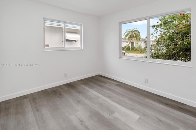 empty room featuring baseboards and wood finished floors