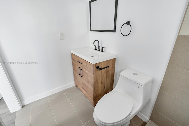 bathroom with tile patterned flooring, baseboards, vanity, and toilet