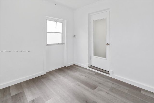 empty room with baseboards and wood finished floors