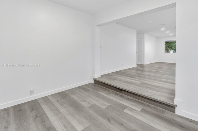 unfurnished room with recessed lighting, wood finished floors, and baseboards