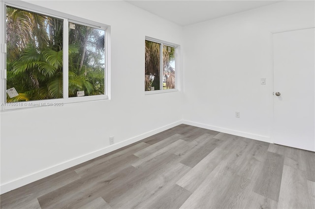 unfurnished room with baseboards and wood finished floors