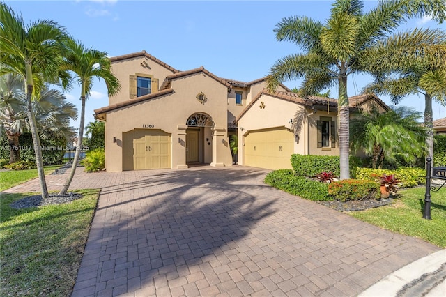 11360 NW 83rd Way, Parkland, FL 33076 - mediterranean / spanish house featuring an attached garage, a tile roof, decorative driveway, and stucco siding