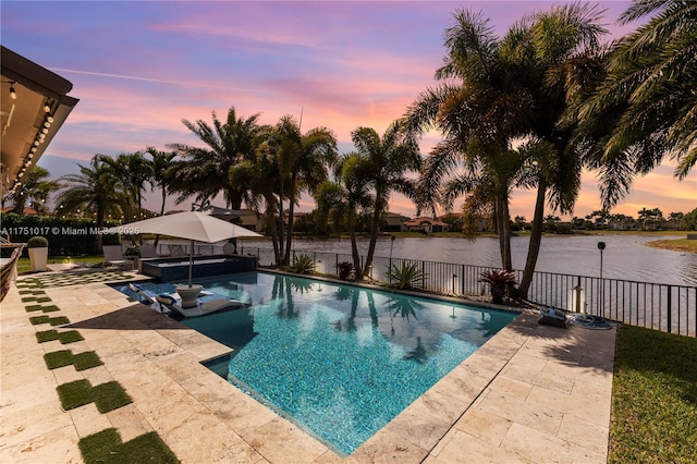 view of swimming pool featuring a water view, a fenced backyard, and a patio area