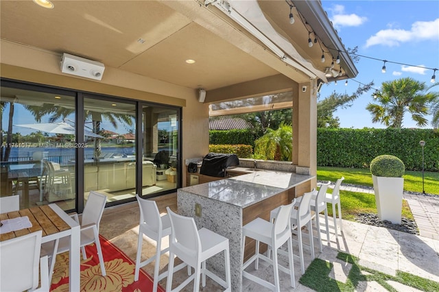 view of patio featuring exterior bar and a grill