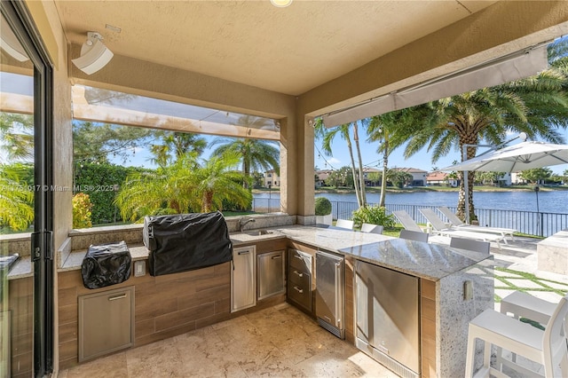 view of patio / terrace featuring fence, a water view, and a grill