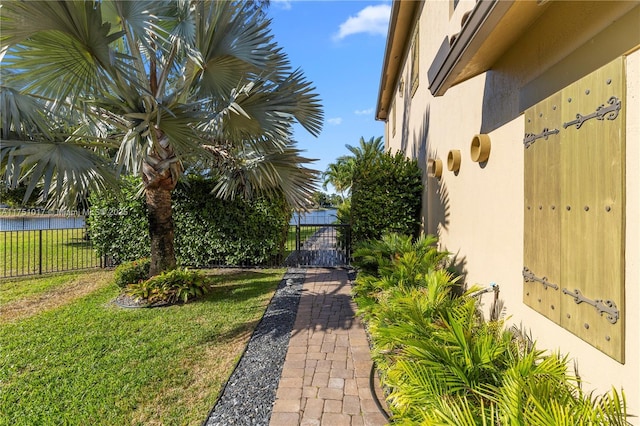 view of yard featuring a gate, a water view, and fence