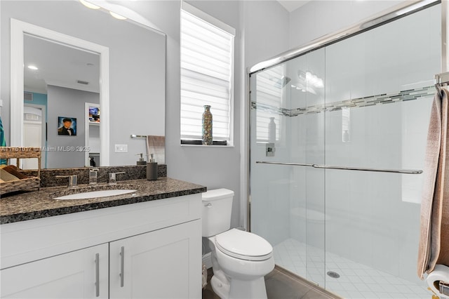 bathroom featuring vanity, toilet, and a shower stall