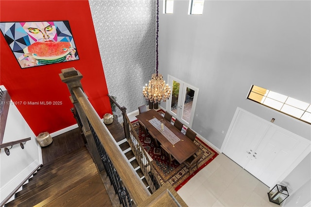 staircase with a chandelier, a high ceiling, and baseboards