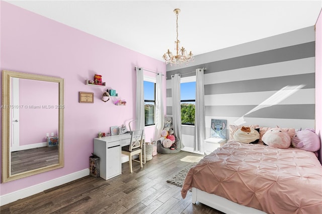 bedroom featuring baseboards, a notable chandelier, and wood finished floors