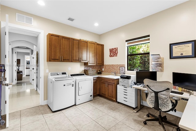 clothes washing area featuring independent washer and dryer, cabinet space, visible vents, and a sink