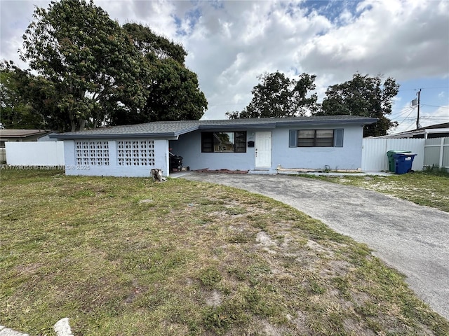 ranch-style house with driveway, a front lawn, fence, and stucco siding