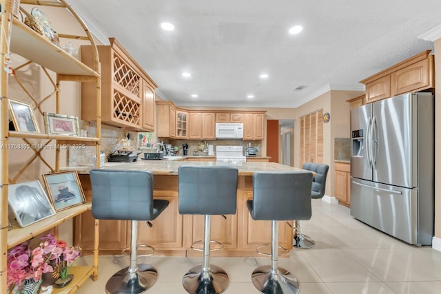 kitchen featuring white microwave, a peninsula, range with electric cooktop, stainless steel fridge, and backsplash