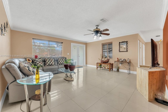 living room featuring light tile patterned floors, visible vents, ceiling fan, and crown molding