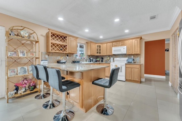 kitchen featuring light brown cabinets, white appliances, crown molding, and a kitchen breakfast bar