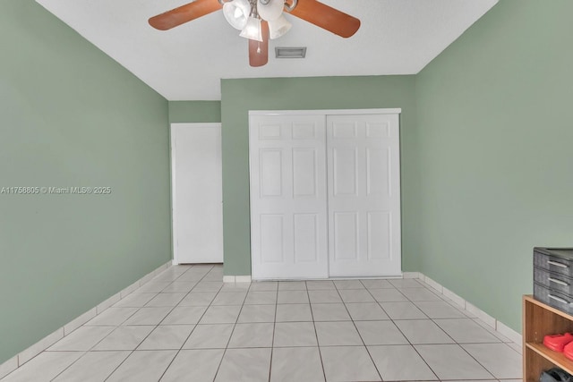 unfurnished bedroom featuring light tile patterned flooring, baseboards, visible vents, and a closet