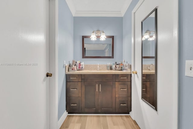 bathroom with ornamental molding, vanity, and wood finished floors