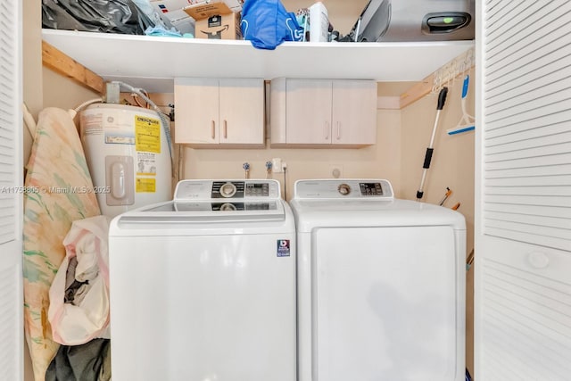 washroom featuring cabinet space, electric water heater, and washing machine and dryer