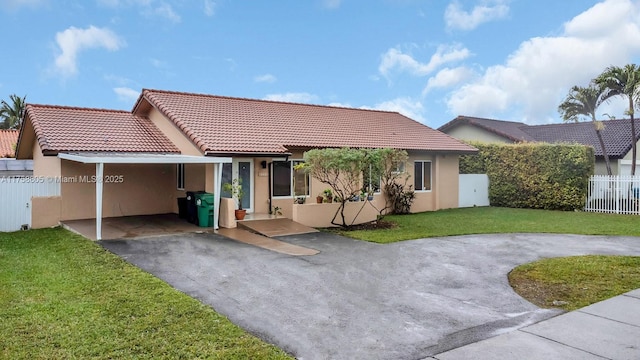 view of front of home featuring stucco siding, a front lawn, fence, an attached carport, and a tiled roof