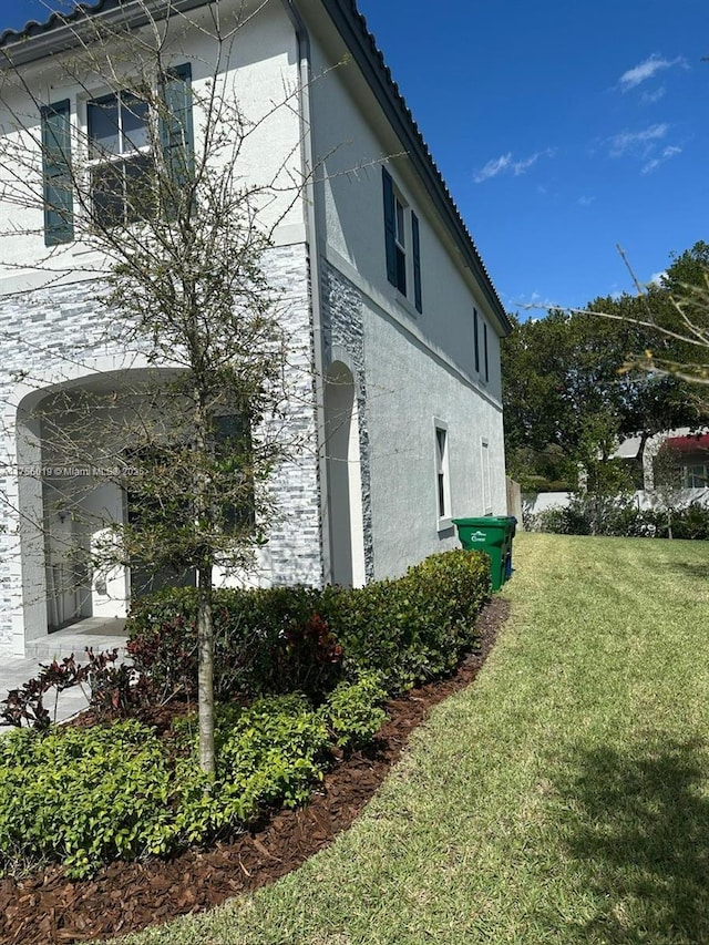 view of home's exterior featuring a yard and stucco siding