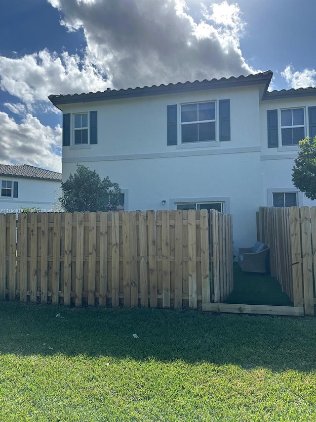 view of home's exterior with a yard, fence, and stucco siding