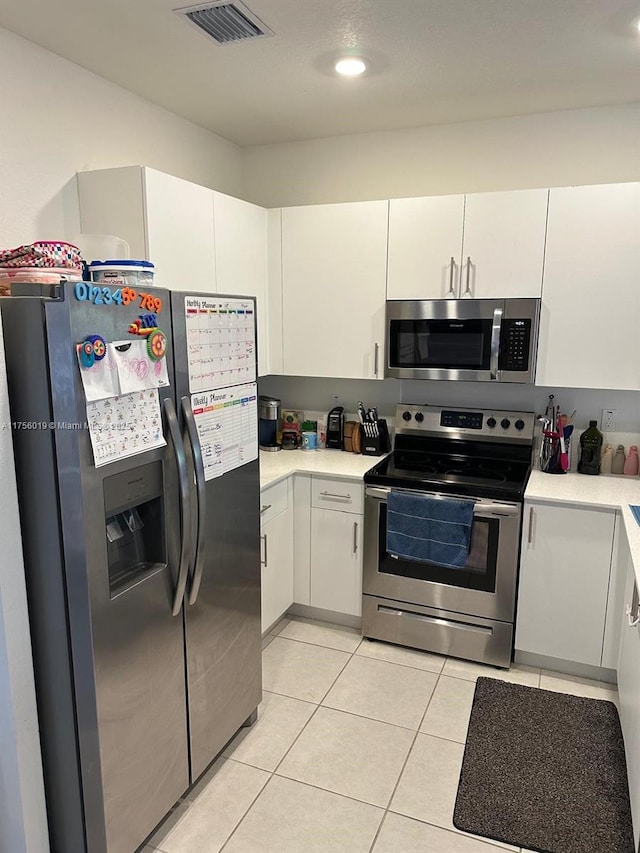 kitchen featuring light tile patterned flooring, visible vents, white cabinetry, light countertops, and appliances with stainless steel finishes