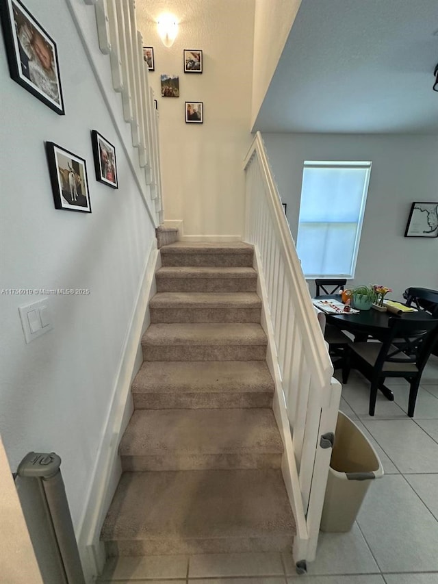 staircase with tile patterned flooring and baseboards