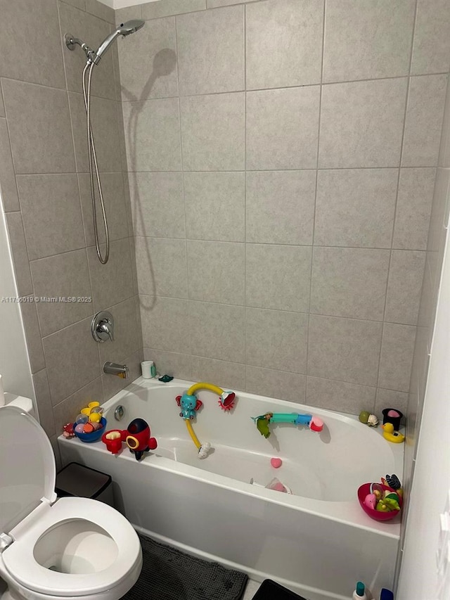 bathroom with shower / bathing tub combination and toilet