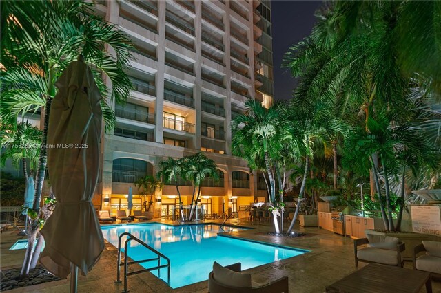3400 SW 27th Ave Unit 705, Miami, FL 33133 - pool at night featuring a community pool and a patio area