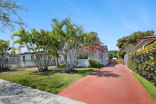 view of front facade featuring a front yard, fence, a gate, and stucco siding