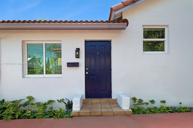 entrance to property featuring stucco siding