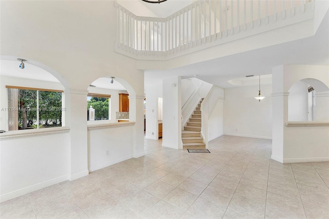 5220 SW 139th Ter, Miramar, FL 33027 - unfurnished living room featuring light tile patterned floors, a high ceiling, and stairs