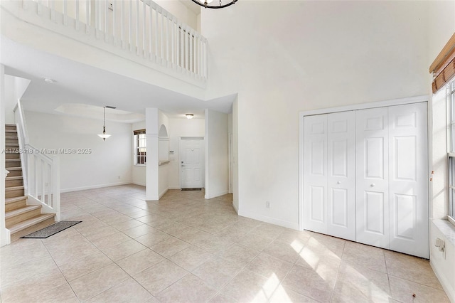 5220 SW 139th Ter, Miramar, FL 33027 - unfurnished living room featuring stairway, a high ceiling, light tile patterned floors, and healthy amount of natural light