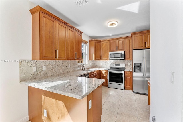 5220 SW 139th Ter, Miramar, FL 33027 - kitchen featuring stainless steel appliances, brown cabinets, and a peninsula