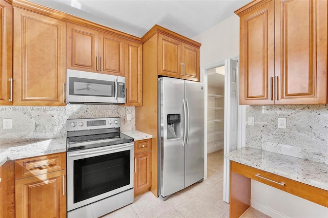 5220 SW 139th Ter, Miramar, FL 33027 - kitchen featuring appliances with stainless steel finishes, decorative backsplash, light tile patterned floors, and light stone countertops
