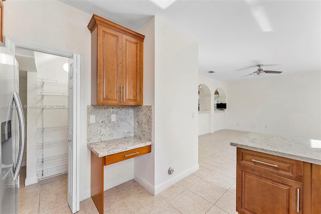 5220 SW 139th Ter, Miramar, FL 33027 - kitchen with stainless steel fridge with ice dispenser, ceiling fan, built in study area, and brown cabinets