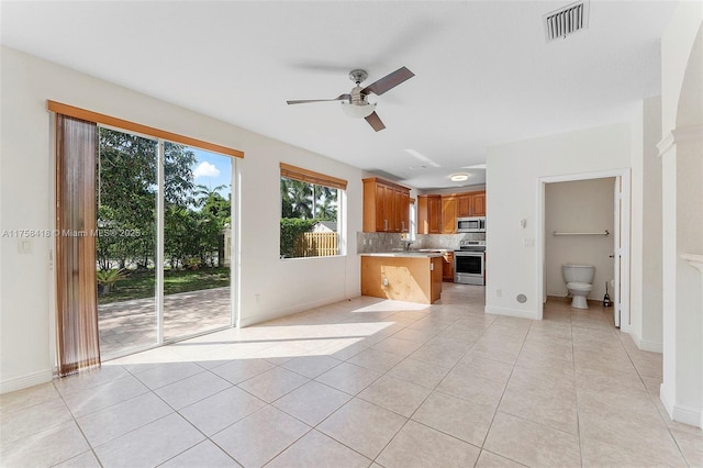 5220 SW 139th Ter, Miramar, FL 33027 - kitchen with stainless steel appliances, light countertops, ceiling fan, light tile patterned floors, and decorative backsplash