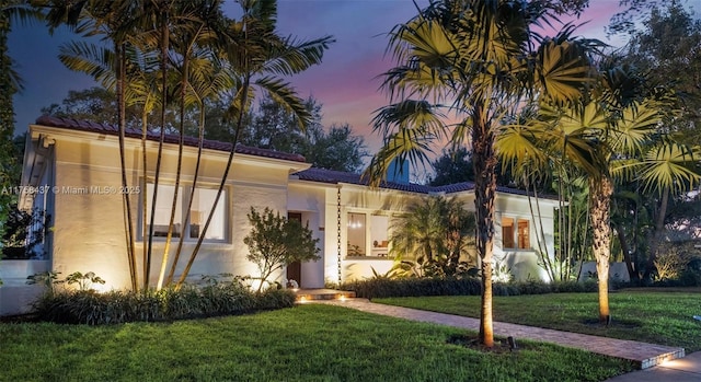 mediterranean / spanish home featuring stucco siding and a front lawn