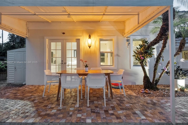 dining space featuring brick floor and french doors