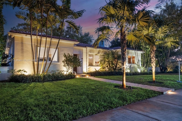 mediterranean / spanish house with a front yard and stucco siding