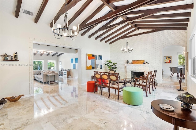 interior space featuring marble finish floor, a fireplace, visible vents, and a notable chandelier