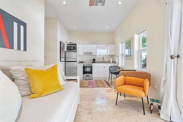 living room with vaulted ceiling with beams, marble finish floor, baseboards, and a wealth of natural light