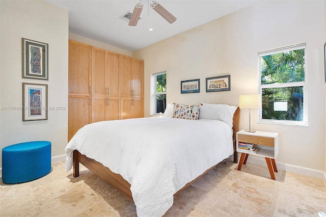 bedroom featuring baseboards, multiple windows, and ceiling fan