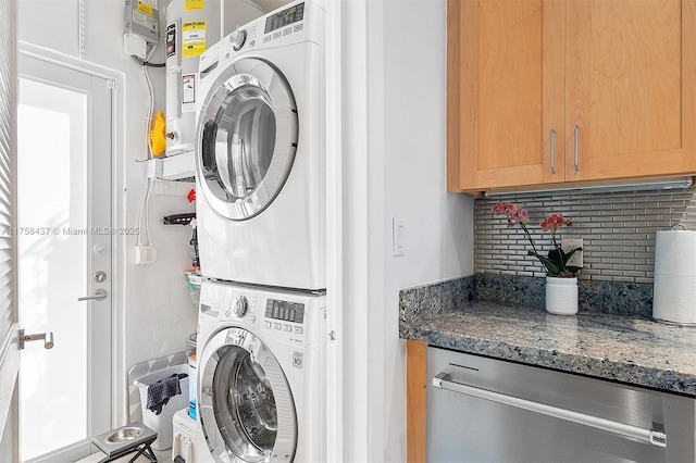 washroom with stacked washer and dryer and cabinet space